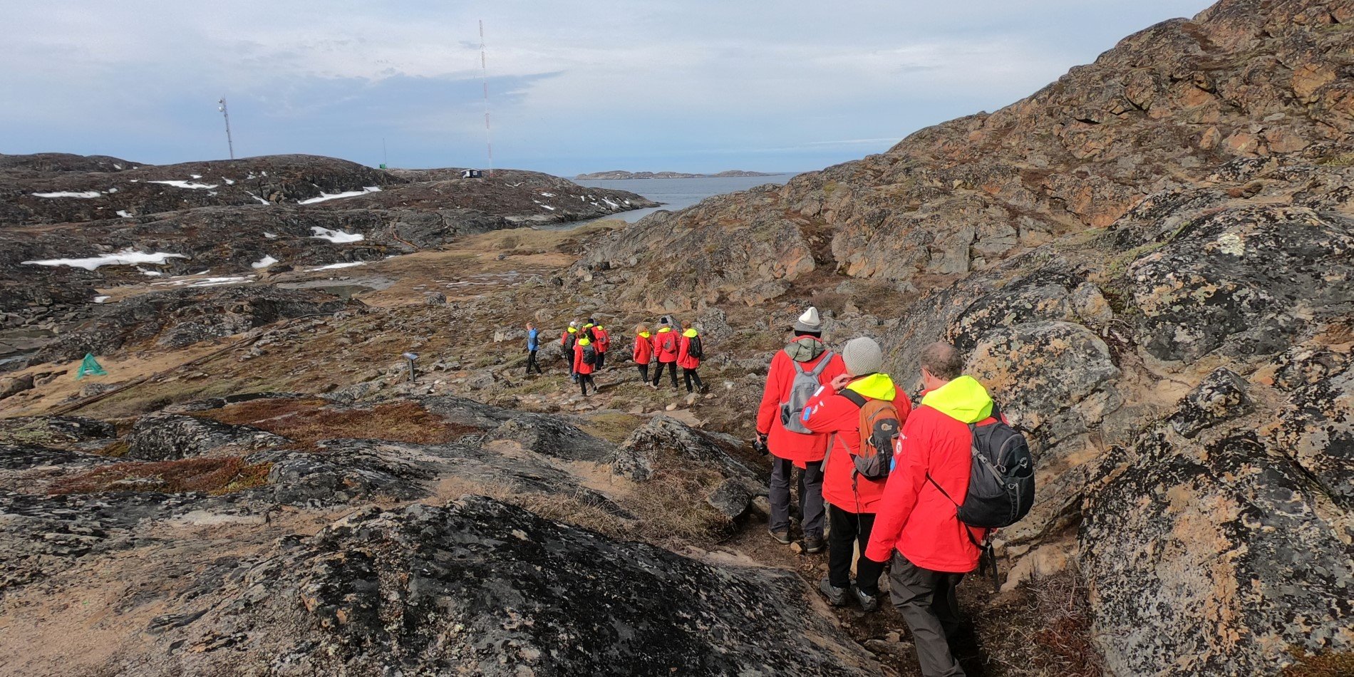 Guests in red Hurtigruten jackets on a cultural hike around Sisimiut, Greenland. 
