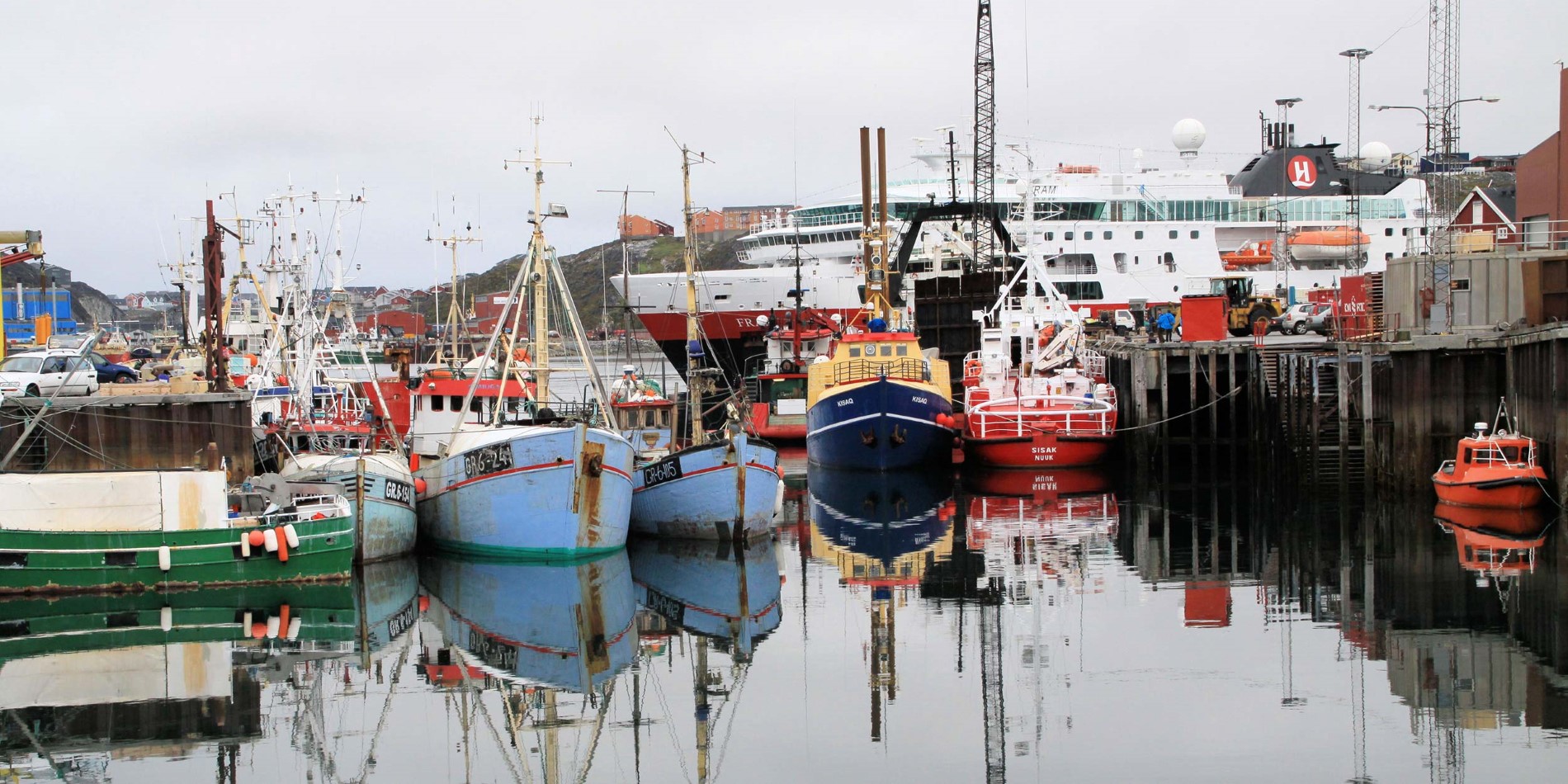 Hurtigruten dans le port de Nuuk avec des bateaux de pêche