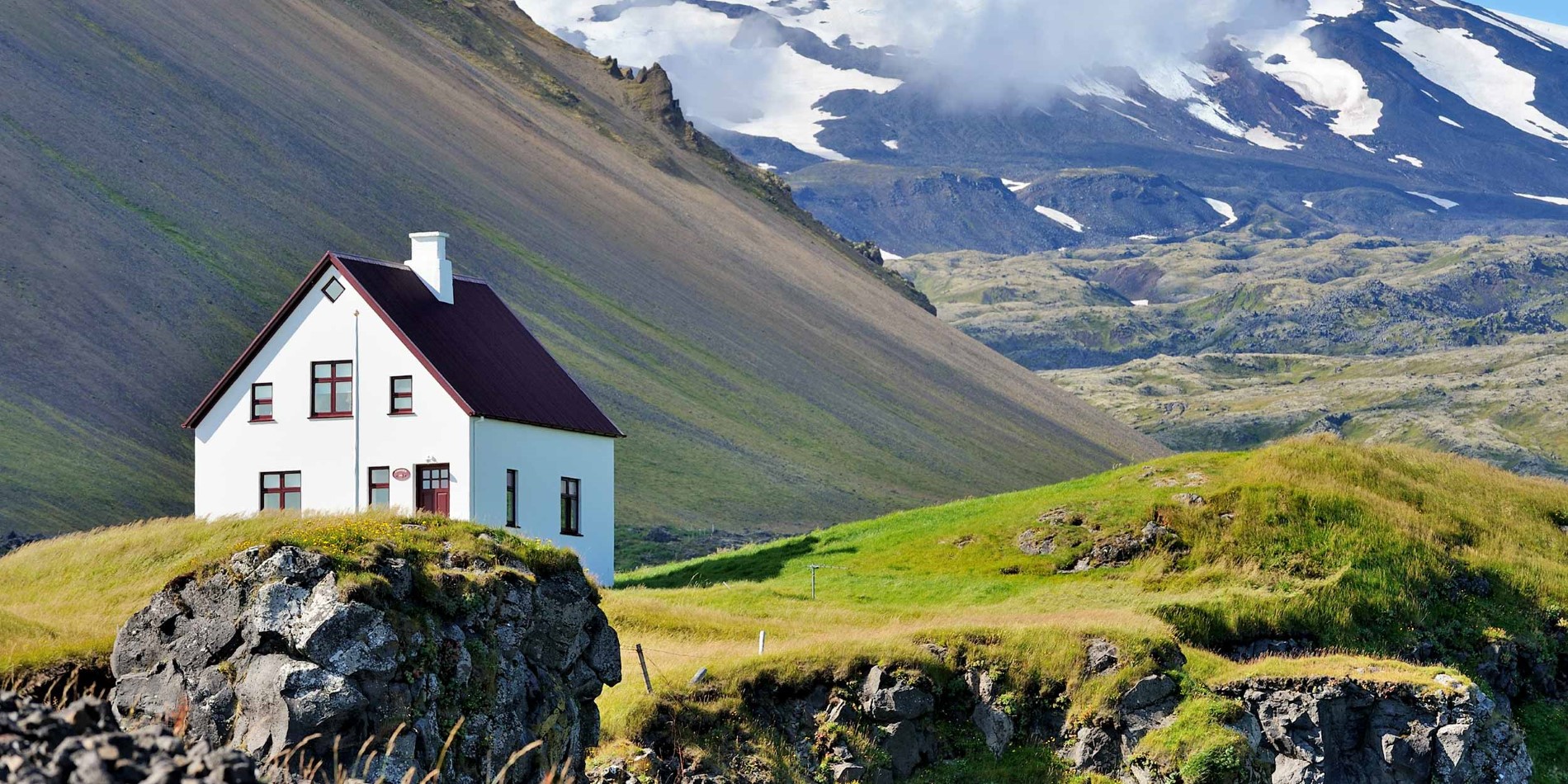Une maison avec une montagne à l'arrière-plan