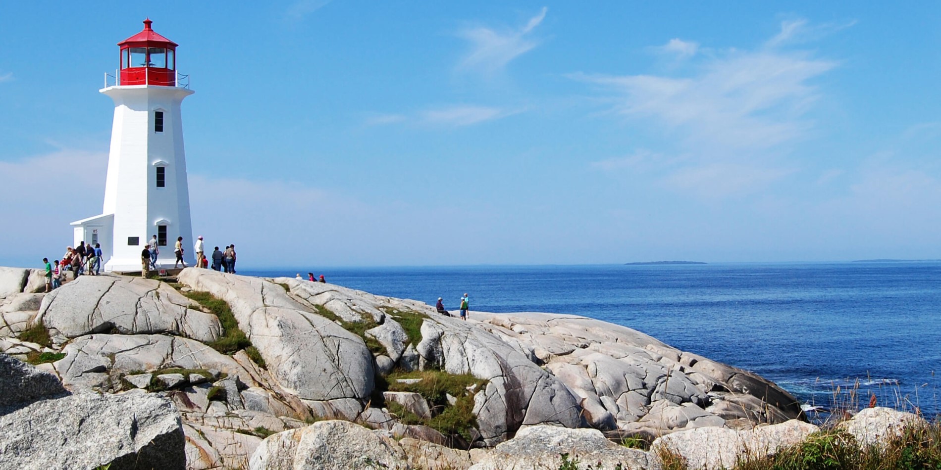 Une statue d'une personne s'asseyant sur un rocher près de l'océan