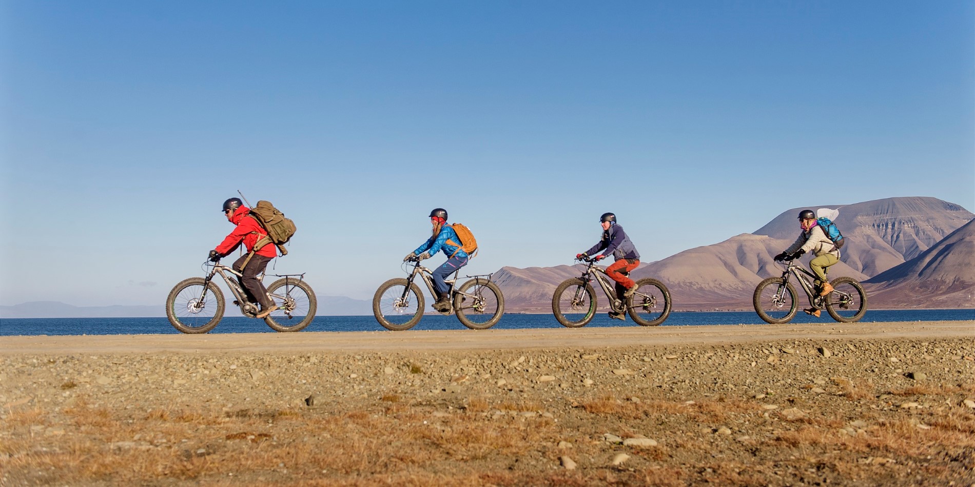 Un groupe de touristes lors d’un tour de Longyearbyen à vélo électrique, au Spitzberg