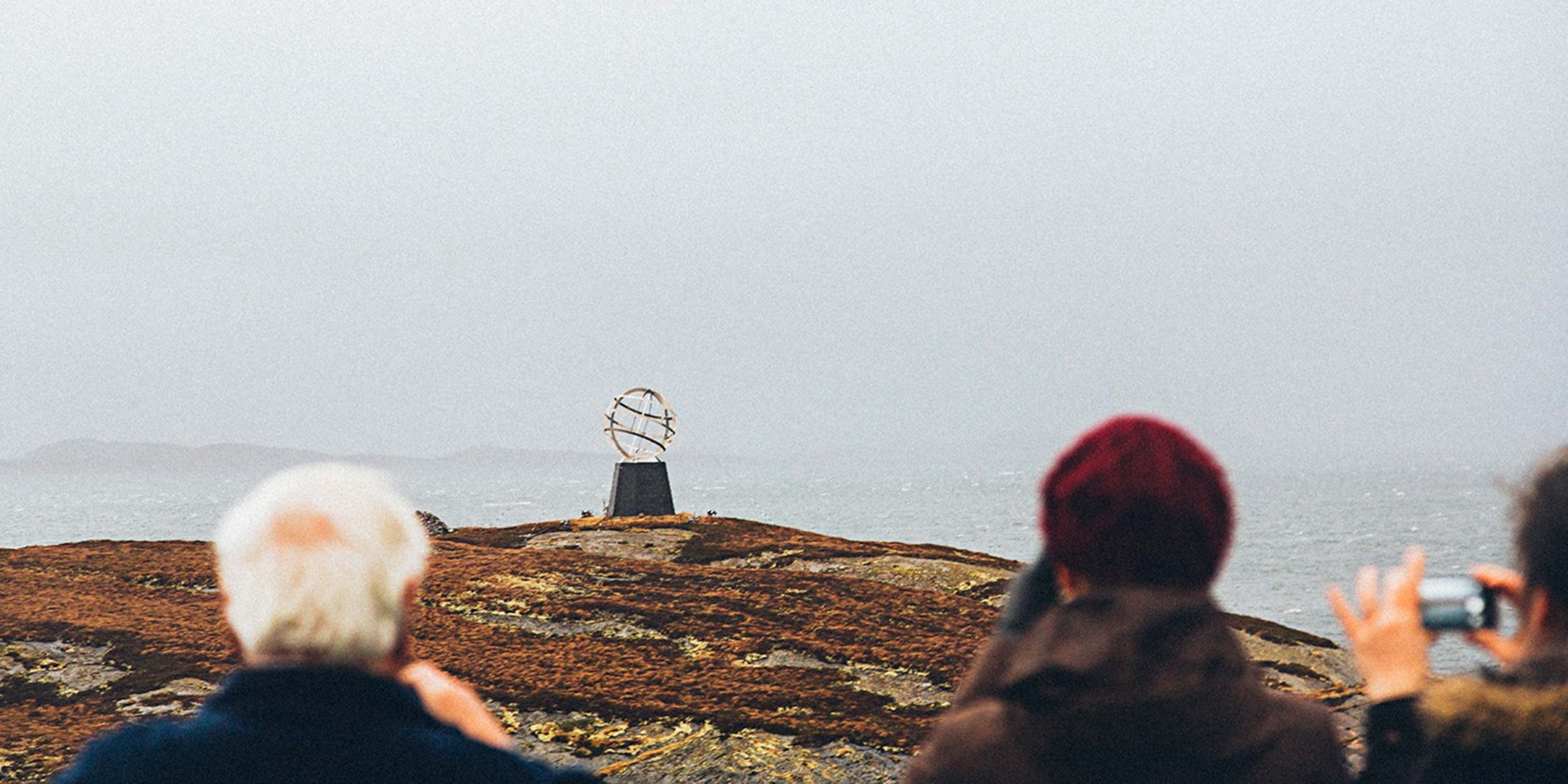 Passagers photographiant le monument du cercle arctique