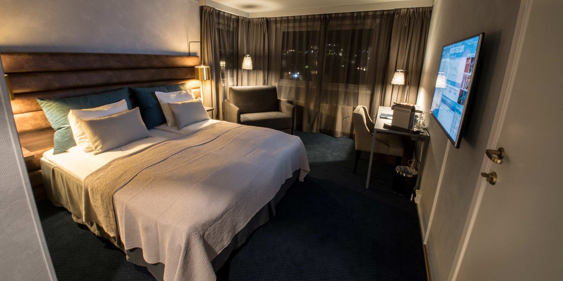 Une chambre avec un lit et un bureau dans une chambre d'hôtel